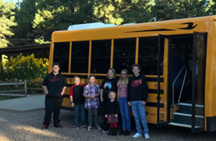 Chevelon Butte students standing in front of school bus