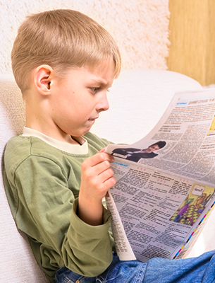 Boy reading a newspaper