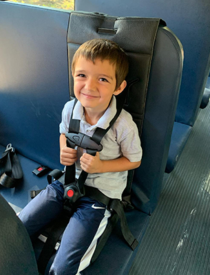 Young student buckled up on a bus seat